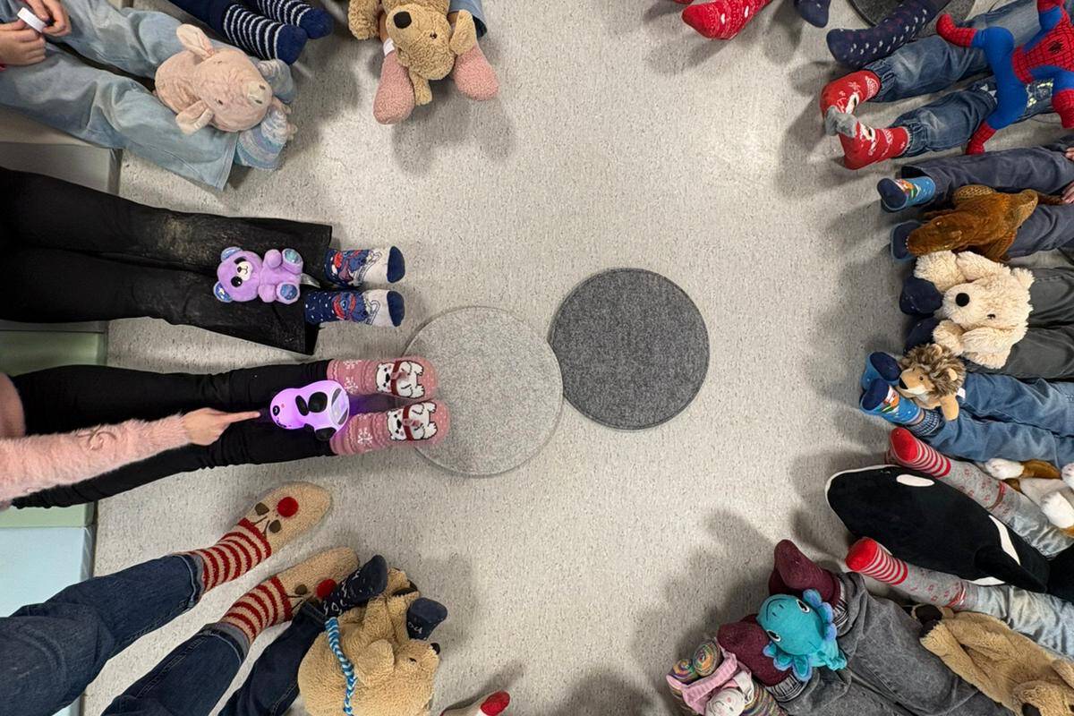 Viele Beine mit verschiedenen Socken sitzen kreisförmig angeordnet nebeneinander