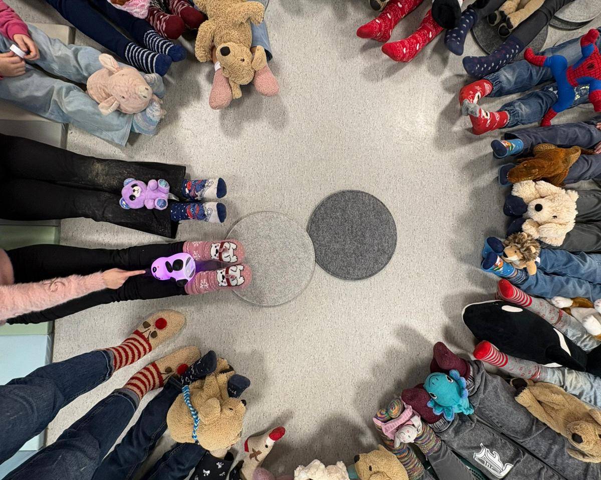 Viele Beine mit verschiedenen Socken sitzen kreisförmig angeordnet nebeneinander