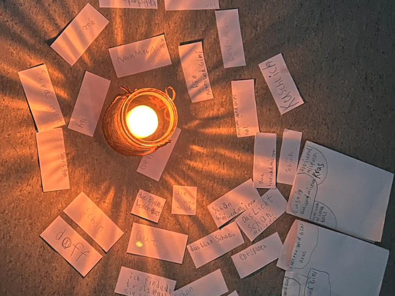 verschiedene Zettel liegen kreisf&ouml;rmig um eine Kerze