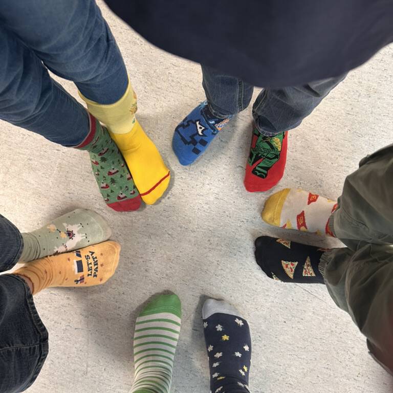 Kinderfüße mit bunten Socken sternförmig angeordnet