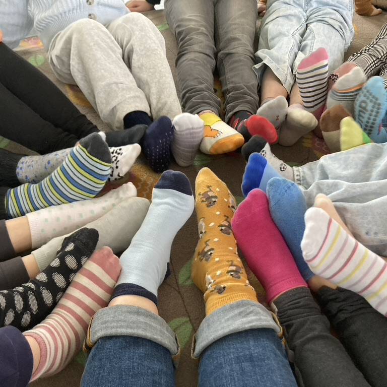 Kinderfüße mit bunten Socken, sternförmig angeordnet