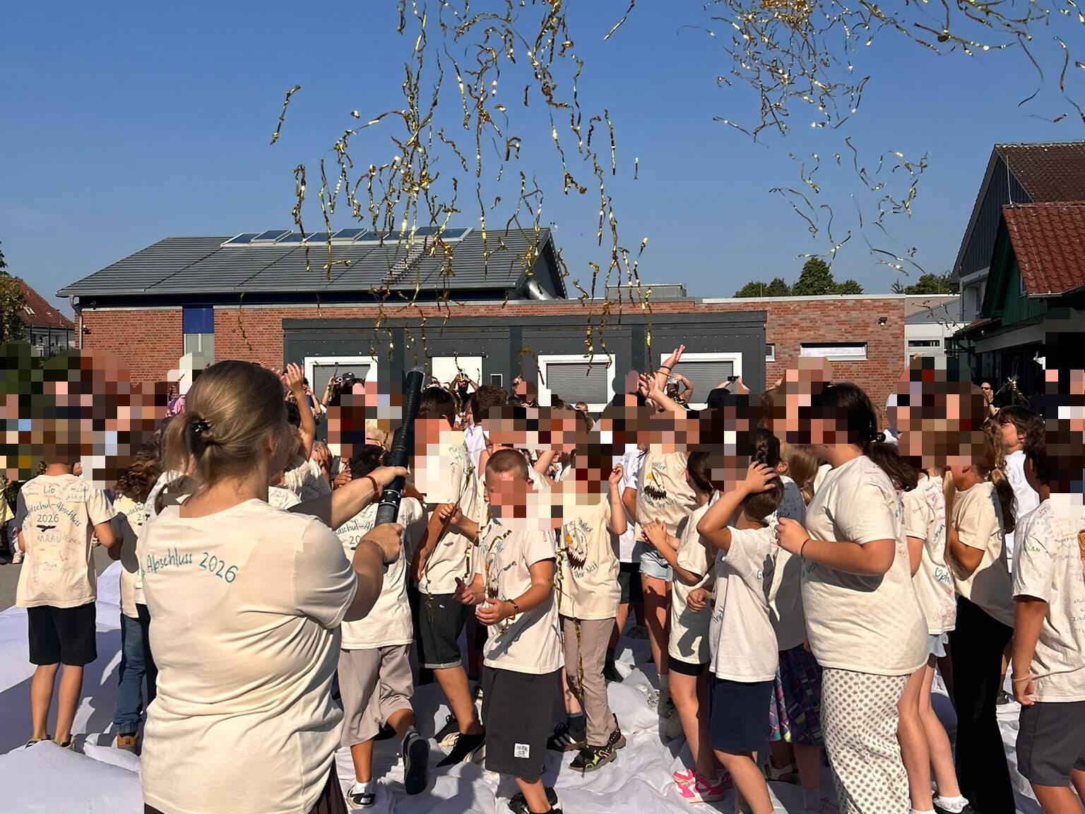 Eine Person von hinten fotografiert wirft Glitzer in die Luft. eine Menschenmenge an Kindern steht vor dem Glitzer, keine Person ist zu erkennen.